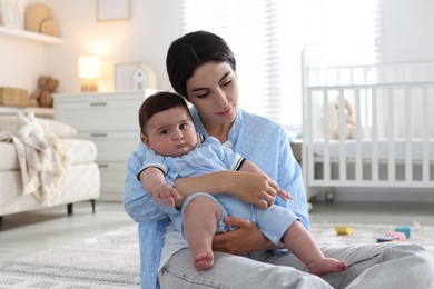 Photo of Woman suffering from postpartum depression with her little baby at home