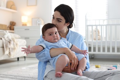Photo of Woman suffering from postpartum depression with her little baby at home