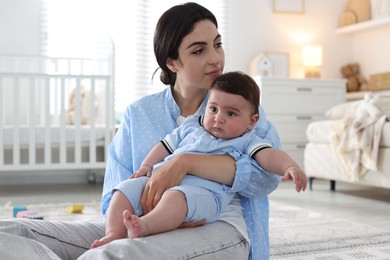 Photo of Woman suffering from postpartum depression with her little baby at home