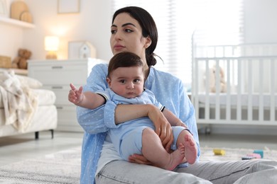 Photo of Woman suffering from postpartum depression with her little baby at home