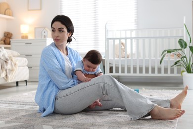 Photo of Woman suffering from postpartum depression with her little baby at home. Space for text