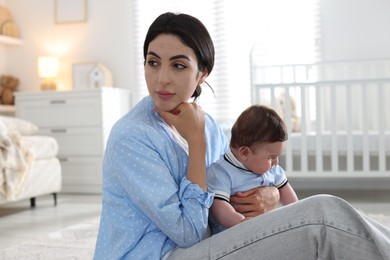 Photo of Woman suffering from postpartum depression with her little baby at home