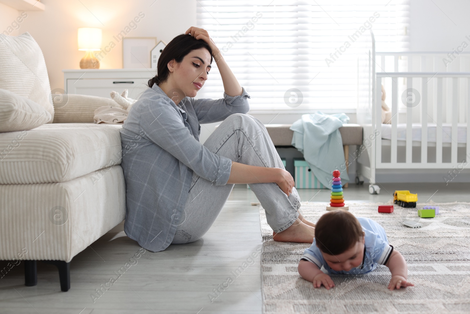 Woman suffering from postpartum depression with her little baby at home. Space for text Photo of Woman suffering from postpartum depression with her little baby at home. Space for text