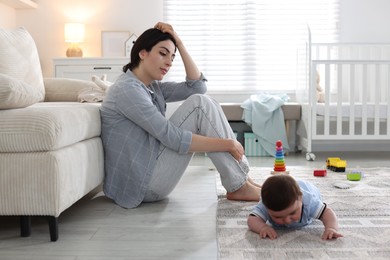 Photo of Woman suffering from postpartum depression with her little baby at home. Space for text