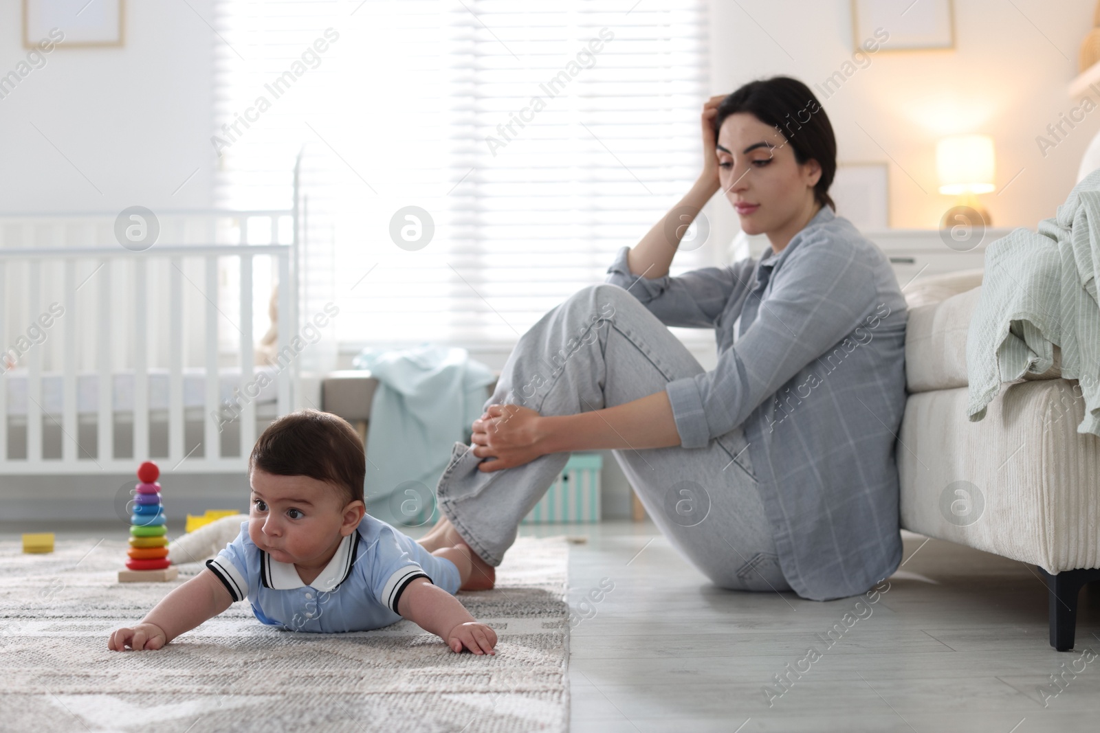 Woman suffering from postpartum depression with her little baby at home. Space for text Photo of Woman suffering from postpartum depression with her little baby at home. Space for text