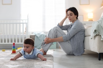 Photo of Woman suffering from postpartum depression with her little baby at home. Space for text