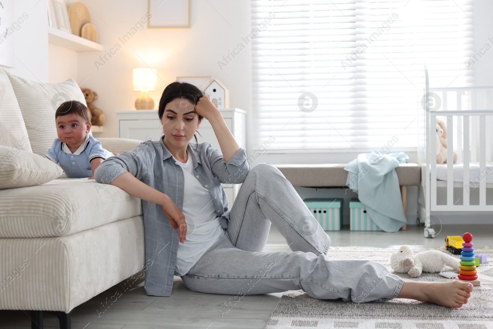 Woman suffering from postpartum depression with her little baby at home. Space for text Photo of Woman suffering from postpartum depression with her little baby at home. Space for text