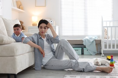Photo of Woman suffering from postpartum depression with her little baby at home. Space for text