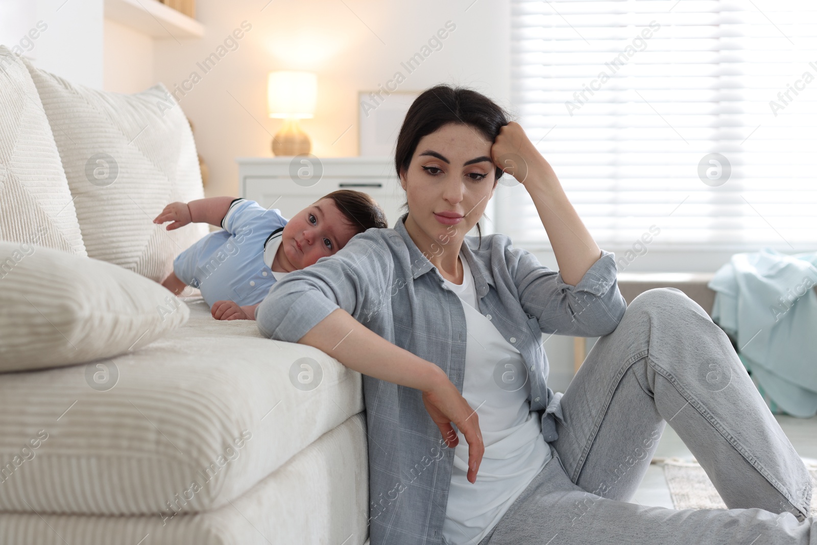 Woman suffering from postpartum depression with her little baby at home Photo of Woman suffering from postpartum depression with her little baby at home