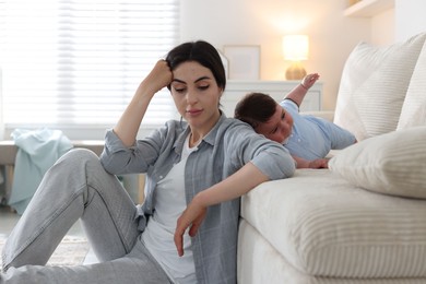 Photo of Woman suffering from postpartum depression with her little baby at home