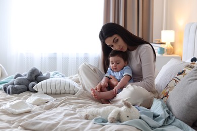 Photo of Woman suffering from postpartum depression with her little baby on bed at home. Space for text