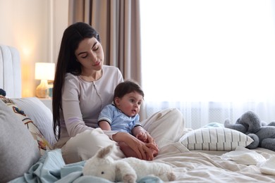 Photo of Woman suffering from postpartum depression with her little baby on bed at home. Space for text