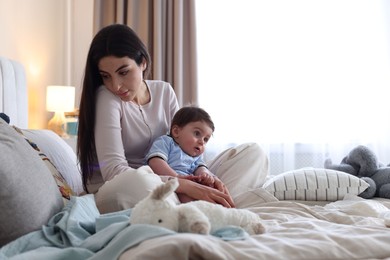 Photo of Woman suffering from postpartum depression with her little baby on bed at home. Space for text