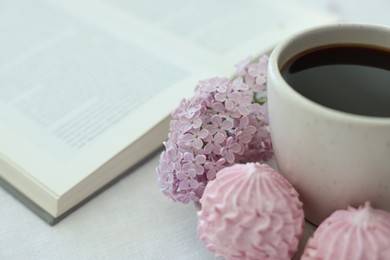 Photo of Coffee with dessert, lilac flowers and book on white table, closeup