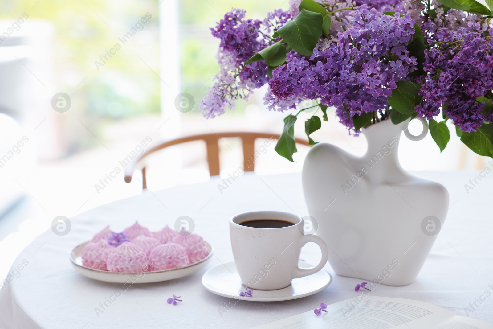 Bouquet of beautiful lilac flowers, coffee and dessert on white table indoors. Space for text Photo of Bouquet of beautiful lilac flowers, coffee and dessert on white table indoors. Space for text