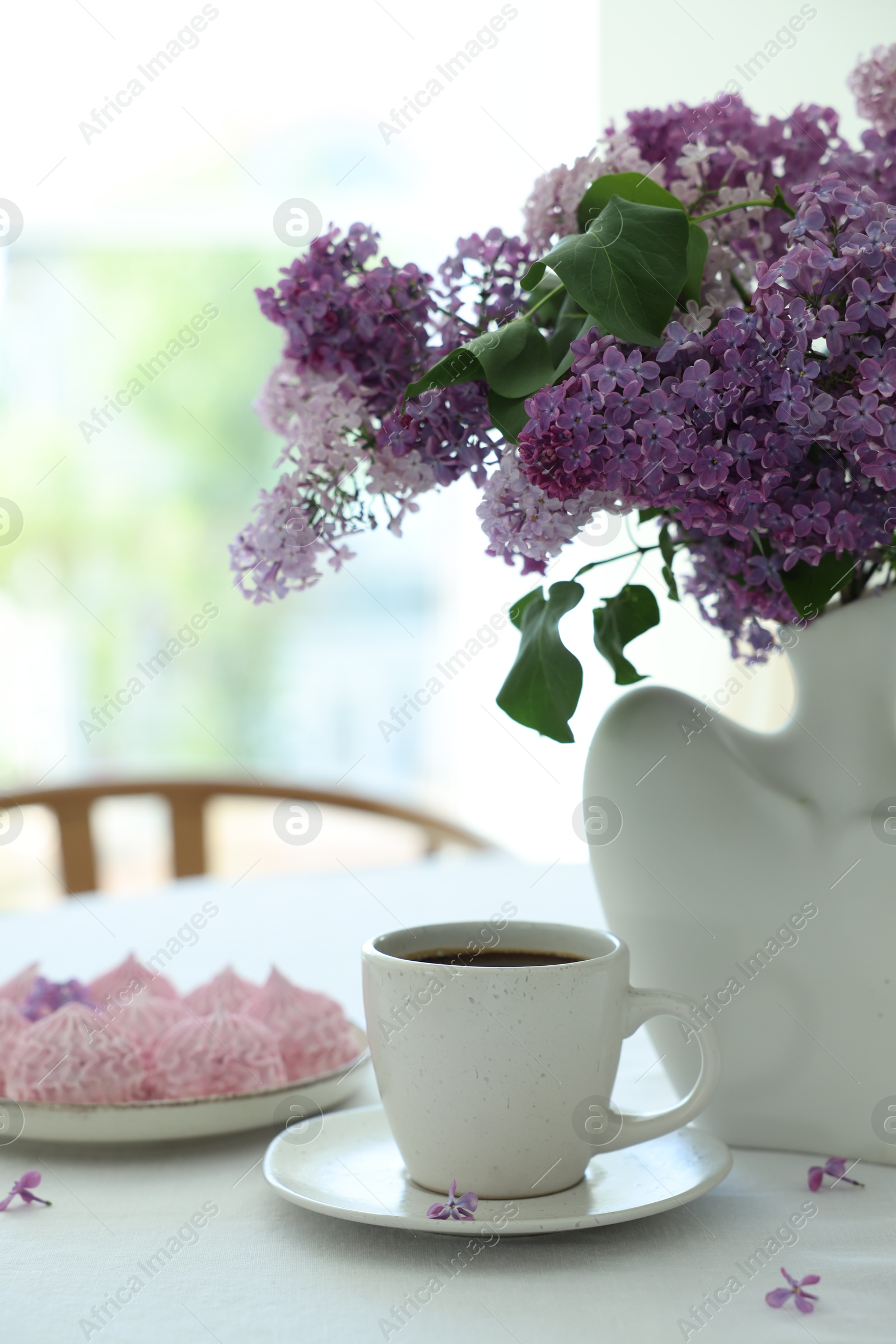 Bouquet of beautiful lilac flowers, coffee and dessert on white table indoors Photo of Bouquet of beautiful lilac flowers, coffee and dessert on white table indoors