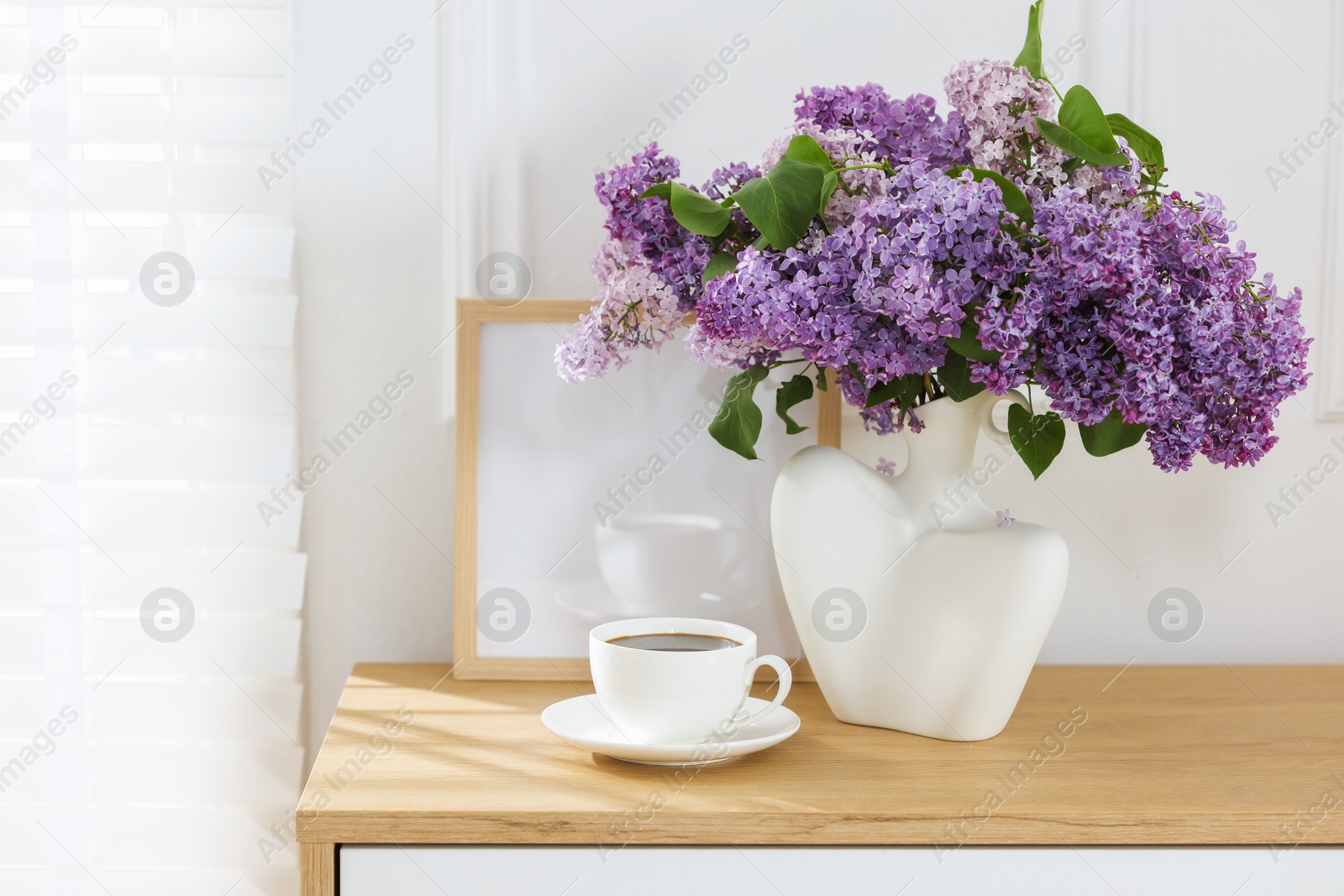 Bouquet of beautiful lilac flowers and coffee on wooden table. Space for text Photo of Bouquet of beautiful lilac flowers and coffee on wooden table. Space for text