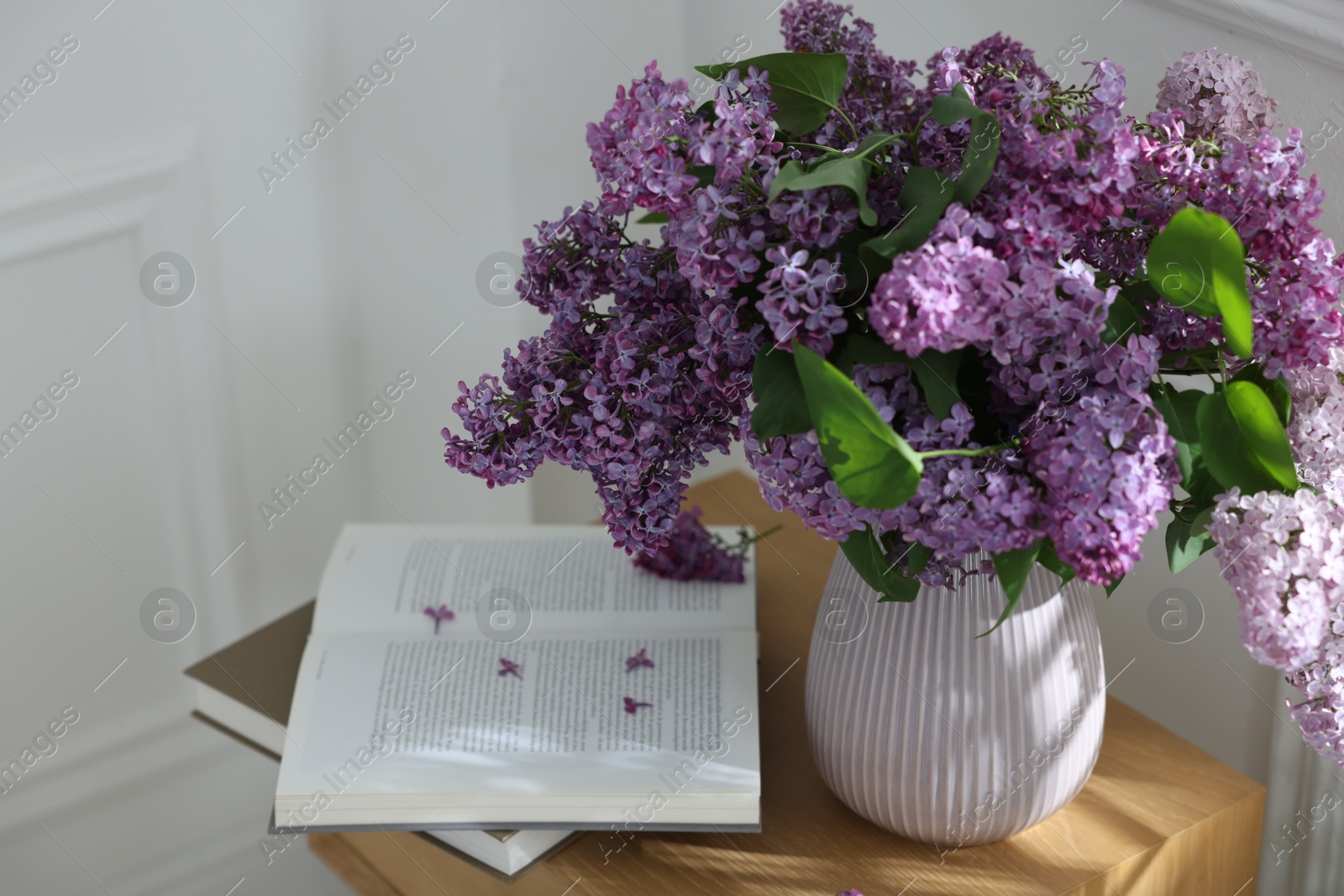 Bouquet of beautiful lilac flowers and books on wooden table Photo of Bouquet of beautiful lilac flowers and books on wooden table
