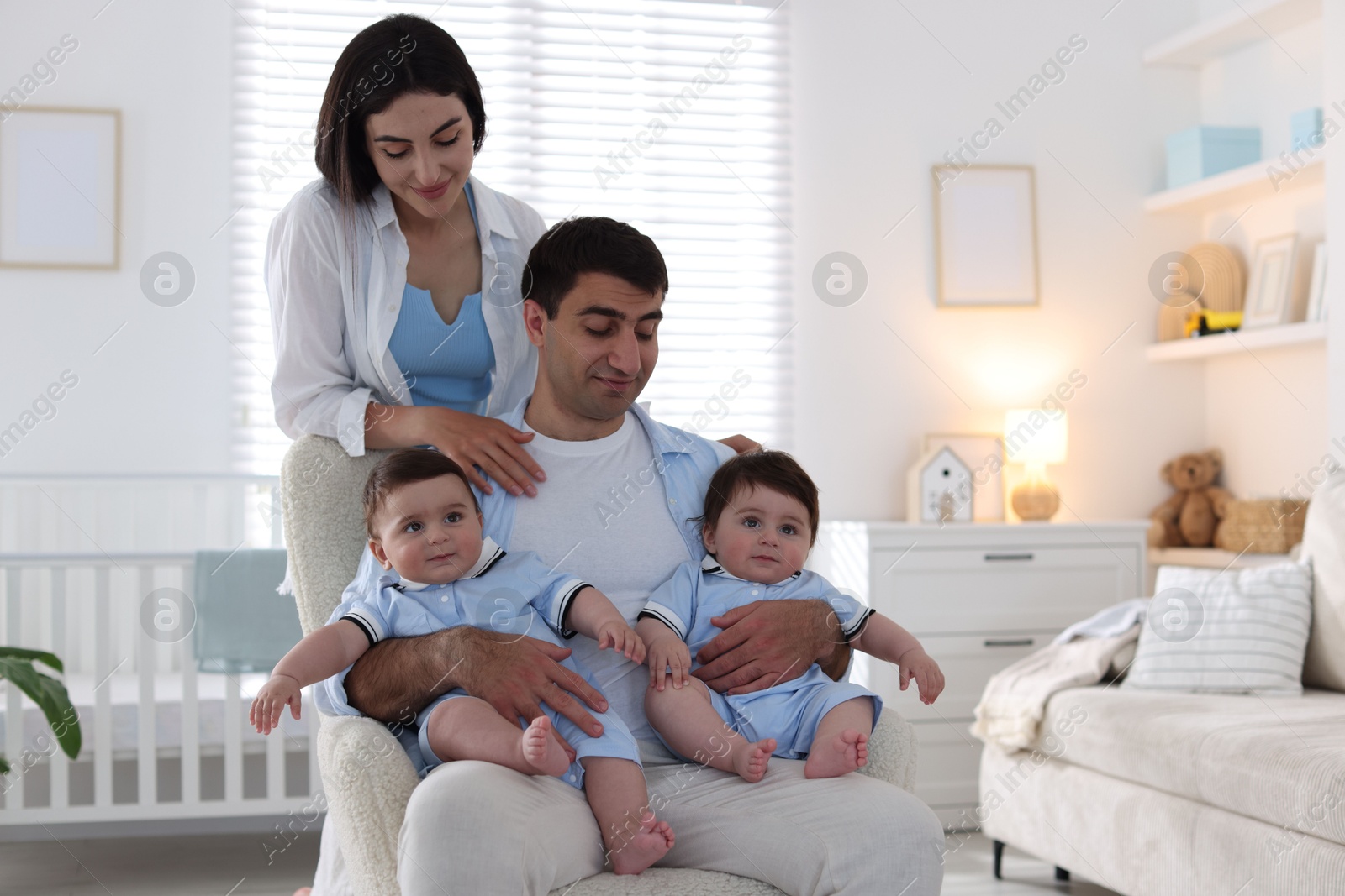 Happy family. Parents with their twin babies at home Photo of Happy family. Parents with their twin babies at home
