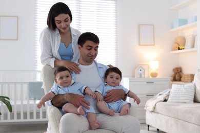 Photo of Happy family. Parents with their twin babies at home
