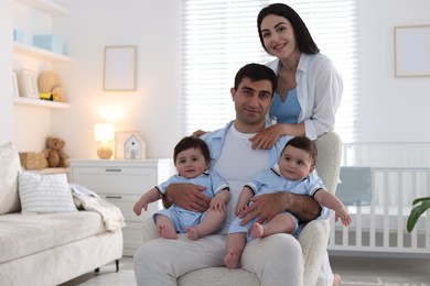 Photo of Happy family. Parents with their twin babies at home