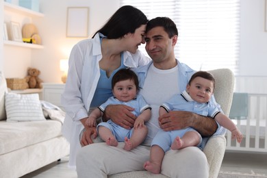 Photo of Happy family. Parents with their twin babies at home