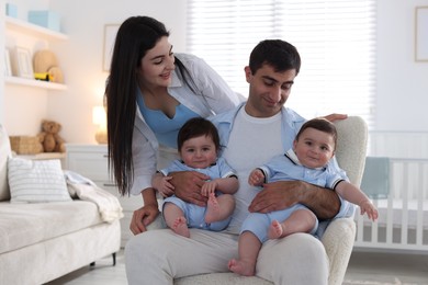 Photo of Happy family. Parents with their twin babies at home