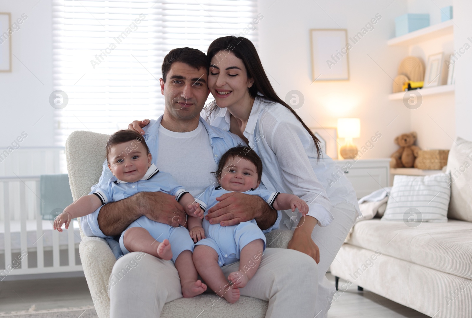 Happy family. Parents with their twin babies at home Photo of Happy family. Parents with their twin babies at home