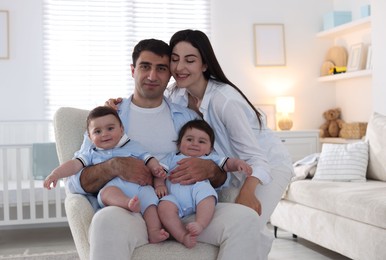 Photo of Happy family. Parents with their twin babies at home