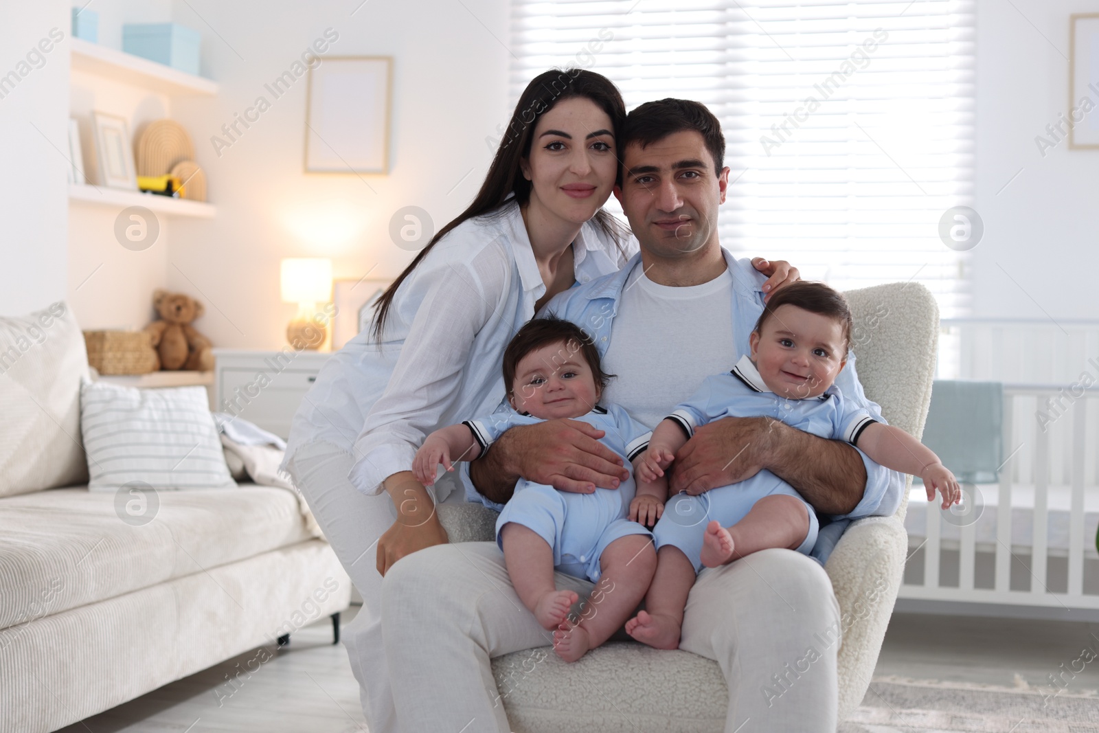 Happy family. Parents with their twin babies at home Photo of Happy family. Parents with their twin babies at home