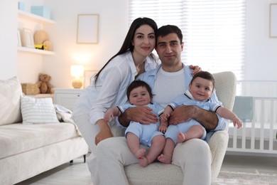 Photo of Happy family. Parents with their twin babies at home