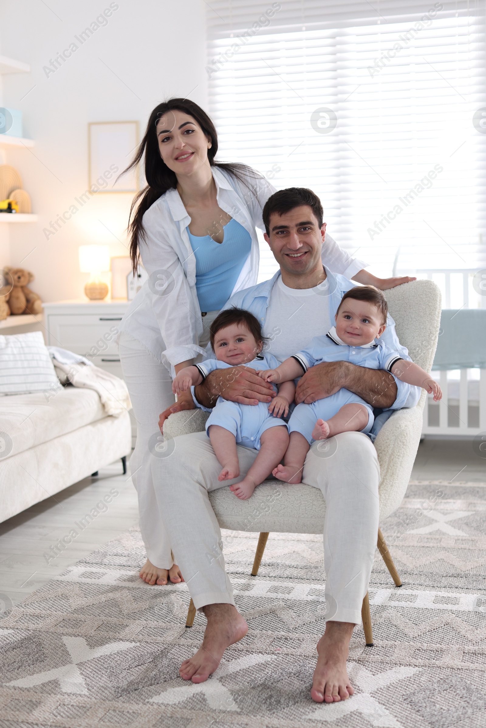 Happy family. Parents with their twin babies at home Photo of Happy family. Parents with their twin babies at home