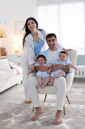 Photo of Happy family. Parents with their twin babies at home