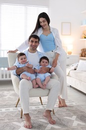 Photo of Happy family. Parents with their twin babies at home