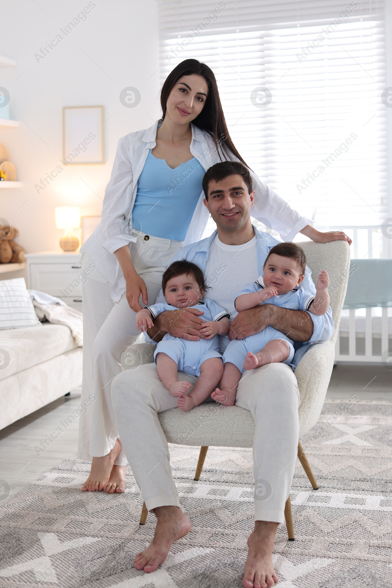 Happy family. Parents with their twin babies at home Photo of Happy family. Parents with their twin babies at home