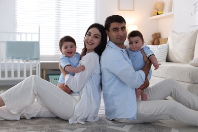 Photo of Happy family. Parents with their twin babies at home