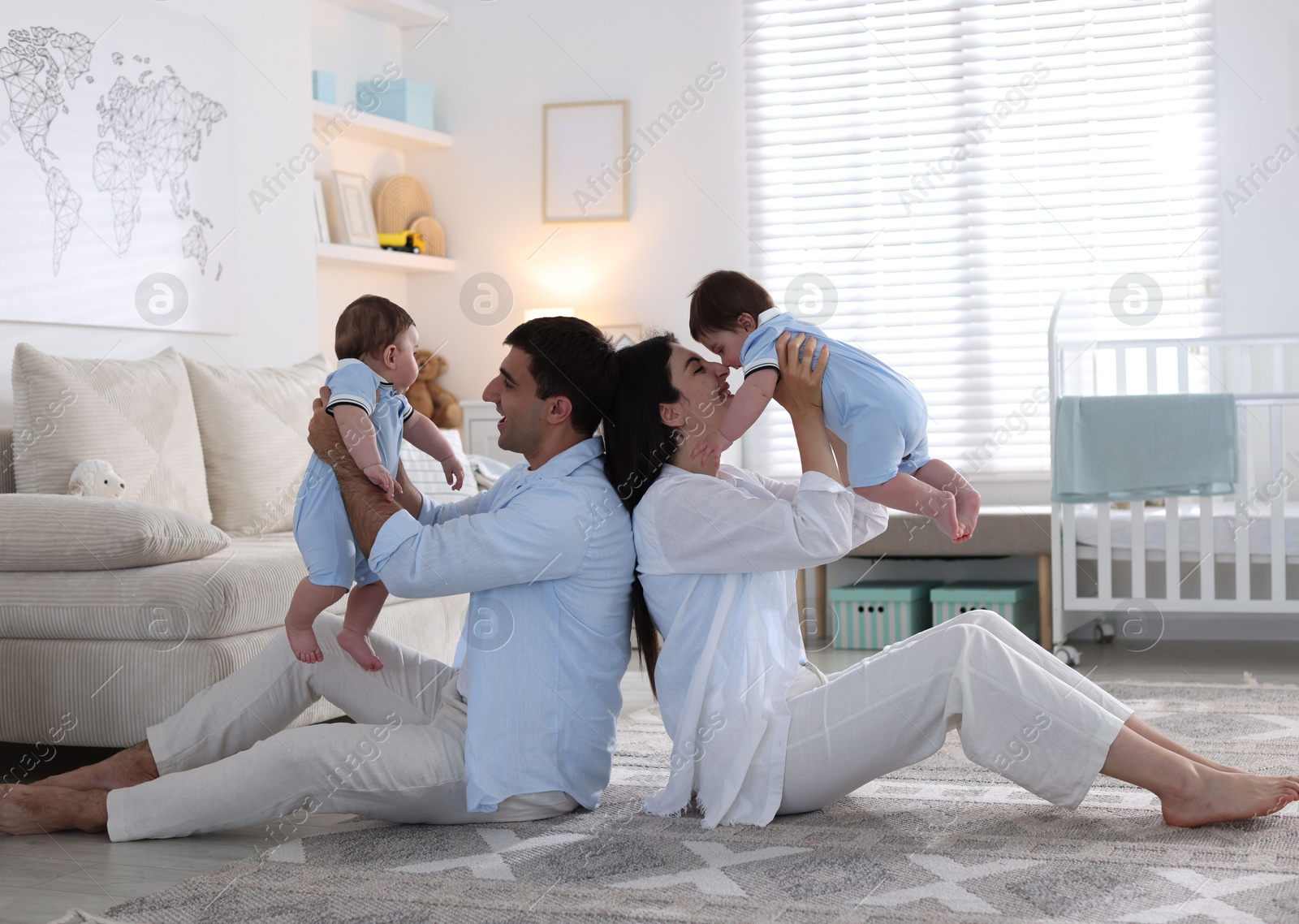Happy family. Parents with their twin babies at home Photo of Happy family. Parents with their twin babies at home