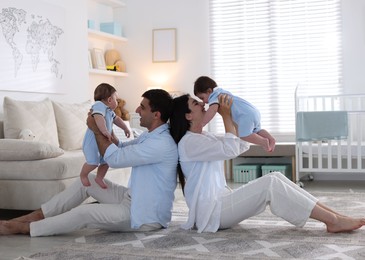 Photo of Happy family. Parents with their twin babies at home