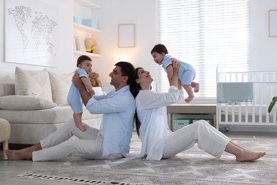 Photo of Happy family. Parents with their twin babies at home