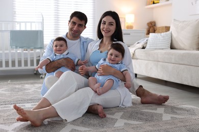 Photo of Happy family. Parents with their twin babies at home