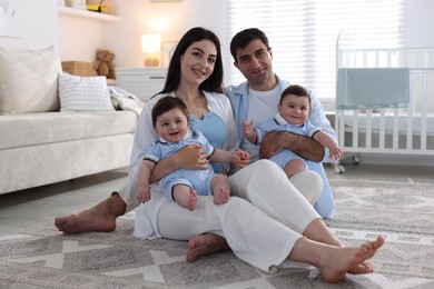 Photo of Happy family. Parents with their twin babies at home