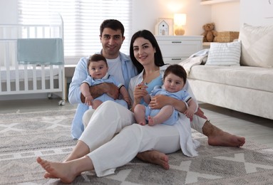 Photo of Happy family. Parents with their twin babies at home