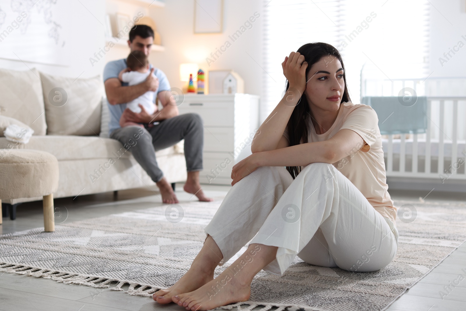 Woman suffering from postpartum depression and her husband with baby at home, selective focus Photo of Woman suffering from postpartum depression and her husband with baby at home, selective focus