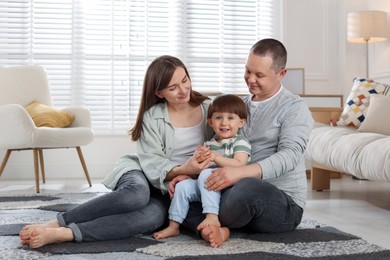 Photo of Cute little boy and his parents at home. Lovely family