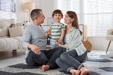 Photo of Cute little boy and his parents at home. Lovely family