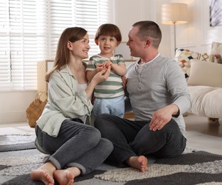 Photo of Cute little boy and his parents at home. Lovely family
