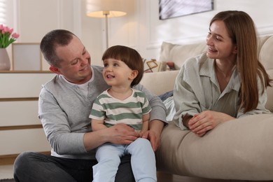 Photo of Cute little boy and his parents at home. Lovely family