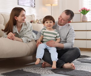 Photo of Cute little boy and his parents at home. Lovely family