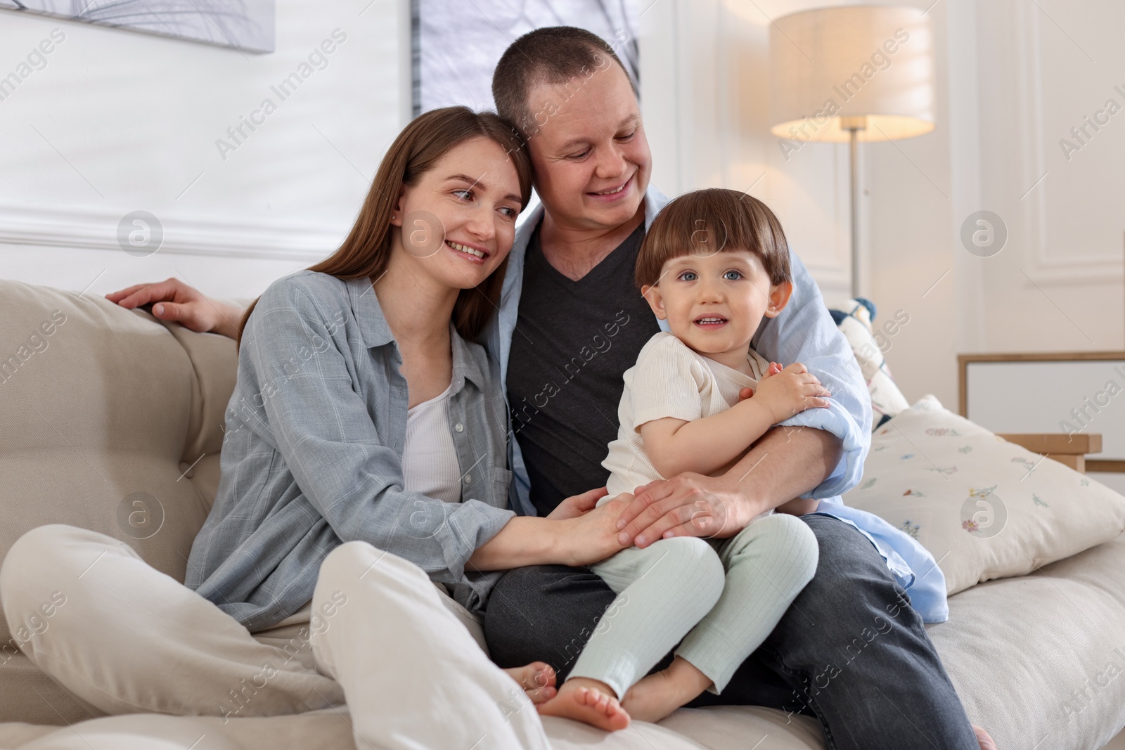 Cute little boy and his parents on sofa at home. Lovely family Photo of Cute little boy and his parents on sofa at home. Lovely family