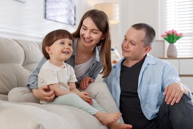 Photo of Cute little boy and his parents on sofa at home. Lovely family